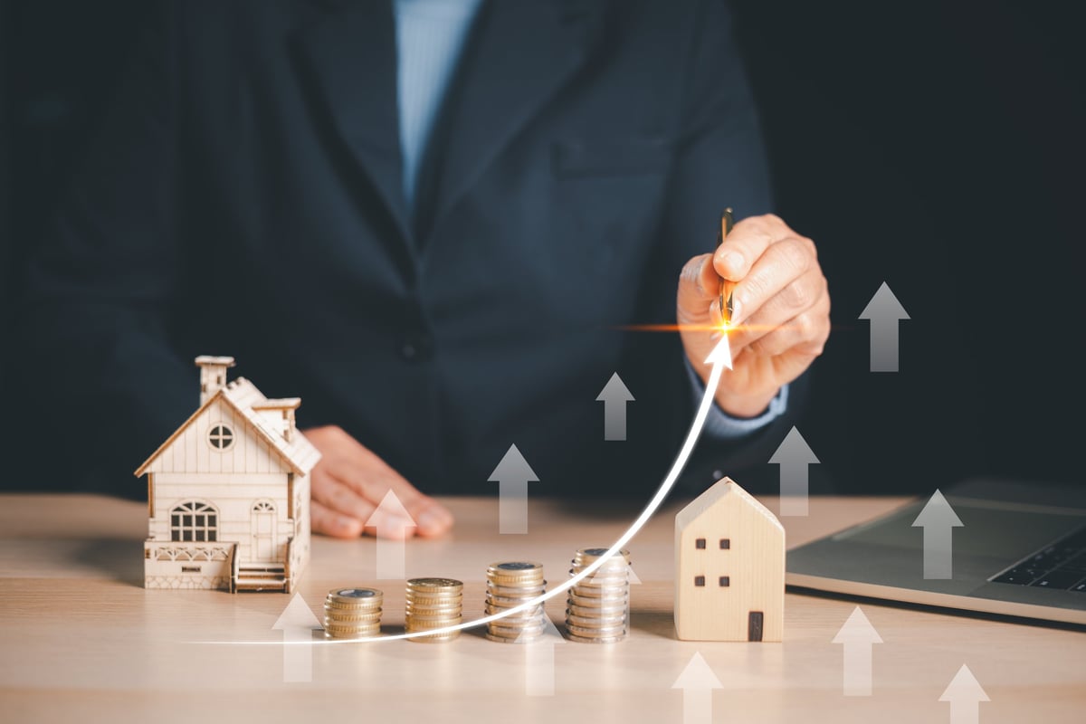 Businessman showing real estate investment growth and increasing property value